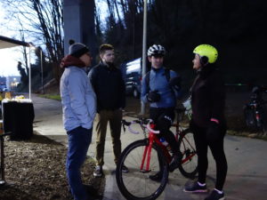 Four people standing and chatting, one with bike, at our Bike Everywhere Day Celebration Station.