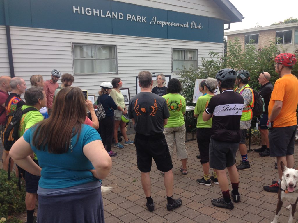 photo of people listening to speaker at Highland Park Improvement Club outdoor space at start of Cycle History Ride with West Seattle Bike Connections and Southwest Seattle Historical Society.