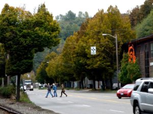 photo of three people crossing West Marginal Way Southwest on foot at the Duwamish Longhouse and Cultural Center