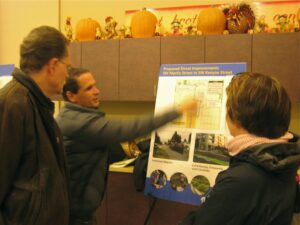 Photo of WSBC members looking at route maps at an SDOT open house for neighborhood greenway projects.