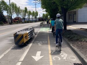 Group of bike riders in protected bike lanes on West Marginal Way SW